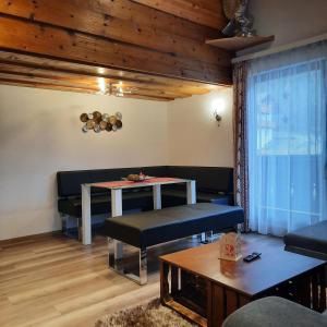 a living room with a table and a couch at Landgasthaus Appartement Birkegg in Leutasch