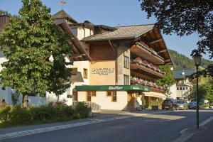 un grand bâtiment sur le côté d'une rue dans l'établissement Pension Ebnerwirt, à Eben im Pongau