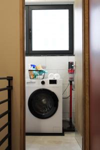 a washing machine in a room with a window at Résidence "Le Vélodrome" in Maubeuge