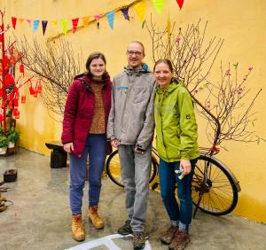 a man and two women standing next to a bike at Trầm Homestay in Thôn An Hòa