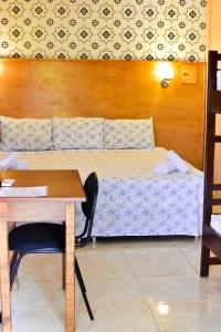 een kleine kamer met een bed en een bureau bij Palmas Park Hotel y Restaurant in Obligado