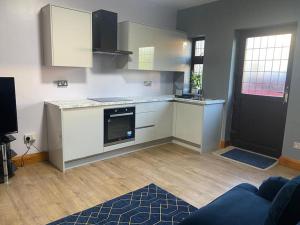 een keuken met witte kasten en een zwarte deur bij Lovely 1 bed Studio Apartment with free parking in Oxford