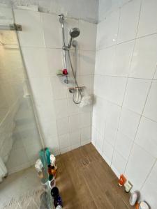 a bathroom with a shower with bottles on the floor at Coco’s Abode in Sydney