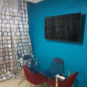 a blue room with two chairs and a flat screen tv at place to be perla 2 saidia in Saïdia