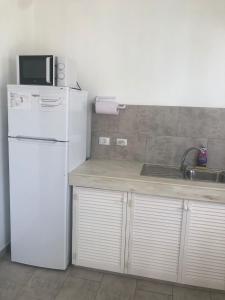 uma cozinha com um frigorífico branco e um lavatório em Downtown apartments em Kralendijk