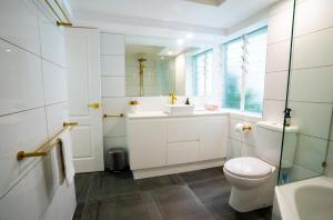 Un baño con inodoro, lavabo y espejo. en The Oasis has a private courtyard and ideal location to walk, en Noosa Heads 12 fotos más