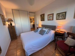 een slaapkamer met een wit bed en een stoel bij Les Collines d'Estanove, charming, bright, calm place with pool in Montpellier