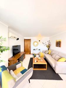 a living room with a couch and a tv at Duplex Sea View by Albufeira Holidays in Albufeira