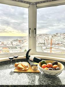 a table with a bowl of fruit and glasses of wine at Duplex Sea View by Albufeira Holidays in Albufeira