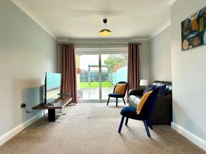 uma sala de estar com um sofá e uma televisão em Spacious 3 double bedroomed house in Bicester em Bicester