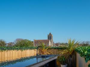 a backyard pool with a fence and plants at The Old Fish Bar in Margate