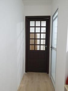 a black door in a room with a wooden floor at Pousada Korb in Santo Amaro da Imperatriz