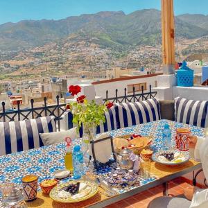 a table with plates of food on top of a balcony at Darna Hostel in Tetouan