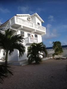 a white building with palm trees in front of it at Downtown apartments in Kralendijk