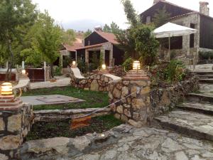 una casa con un muro di pietra e un cortile di Alojamientos Turisticos La Utrera a Las Majadas
