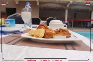 um prato de croissants e pão numa mesa em Hotel Hayatt em Nouakchott