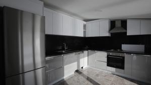 eine schwarz-weiße Küche mit weißen Schränken und einem Waschbecken in der Unterkunft Ulus Suites in Istanbul