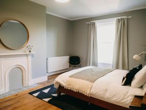 a bedroom with a bed with a mirror and a fireplace at No 1 Pepper Arden in Northallerton