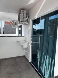 a bathroom with a sink and a glass shower at Águas Rasas - Flats in Arraial do Cabo