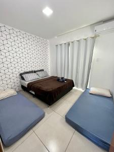 a bedroom with two beds and two blue mattresses at Águas Rasas - Flats in Arraial do Cabo