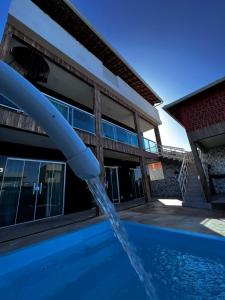 a water fountain in front of a building at Águas Rasas - Flats in Arraial do Cabo +9 photos