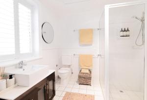 a white bathroom with a toilet and a shower at 70 On Mortimer in Mudgee +46 photos