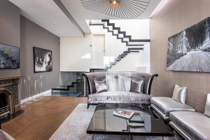 a living room with a couch and a table and stairs at Mews house in London
