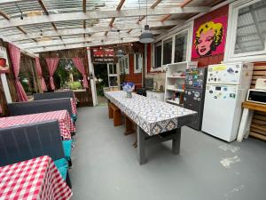 a dining room with a table and a refrigerator at La Guapa Hostel in Puerto Varas