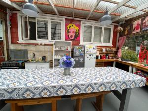 a kitchen with a table with a vase of flowers on it at La Guapa Hostel in Puerto Varas