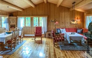 una sala de estar con paredes de madera, mesas y sillas en Amazing Home In l With 5 Bedrooms, en Al