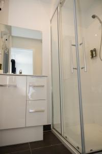 een badkamer met een glazen douche en een wastafel bij Tullah Lakeside Lodge in Tullah