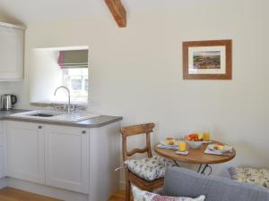 a kitchen with a sink and a table in a room at Spindle Well Barn in Elsdon