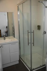 a bathroom with a glass shower and a sink at Tullah Lakeside Lodge in Tullah