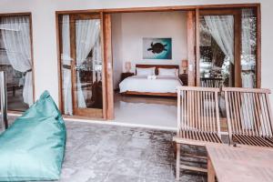 1 dormitorio con 1 cama y puertas correderas de cristal en Kelapa Kecil, en Gili Trawangan