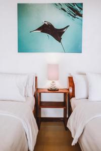 a bedroom with two beds and a dolphin painting on the wall at Kelapa Kecil in Gili Trawangan