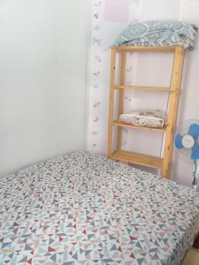 Dormitorio pequeño con cama y estante en Condomínio agradável Familiar, en Matinhos