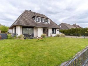 a house with a green yard with a house at Ferienwohnung Küstenluft in Tating in Tating