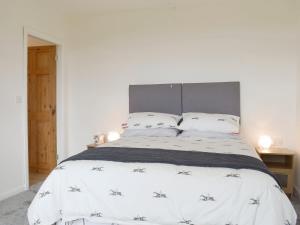 una camera da letto con un grande letto con lenzuola e cuscini bianchi di Barley Heights a Hapton