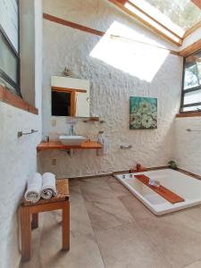 a bathroom with a bath tub and a sink at Canto de Aves in Malinalco