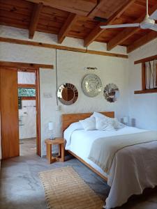 a bedroom with a bed and two mirrors on the wall at Canto de Aves in Malinalco