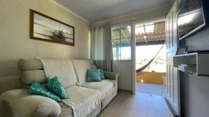 sala de estar con sofá y ventana en Casa próx ao mar de Penha praia vermelha e Beto Carrero, en Penha
