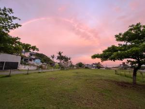 un arco iris en el cielo sobre un campo de hierba en Casa próx ao mar de Penha praia vermelha e Beto Carrero, en Penha