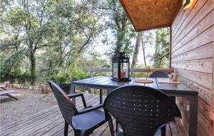 uma mesa e cadeiras num deque de madeira com árvores em 2 Bedroom Cozy Home In Lorgues em Lorgues