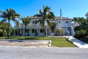 une maison blanche avec des palmiers devant elle dans l'établissement Sundowner Villa villa, à Savannah Sound
