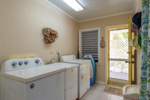 a kitchen with a washer and dryer and a window at Sundowner Villa villa in Savannah Sound