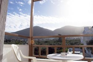 a table and chairs on a balcony with a view of mountains at Hotel Velissarios in Hersonissos