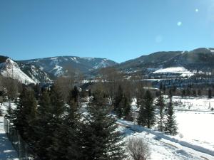a snow covered slope with trees and mountains at Beaver Creek West Condos in Avon