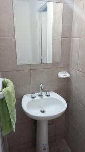 y baño con lavabo blanco y espejo. en Alojamientos Malargüe en Malargüe