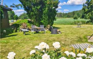 einen Hof mit einem Picknicktisch und weißen Blumen in der Unterkunft Lovely Home In Vler I stfold With Jacuzzi 