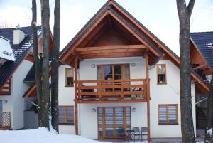 a house in the woods with a balcony at Apartament pod Śnieżką in Karpacz